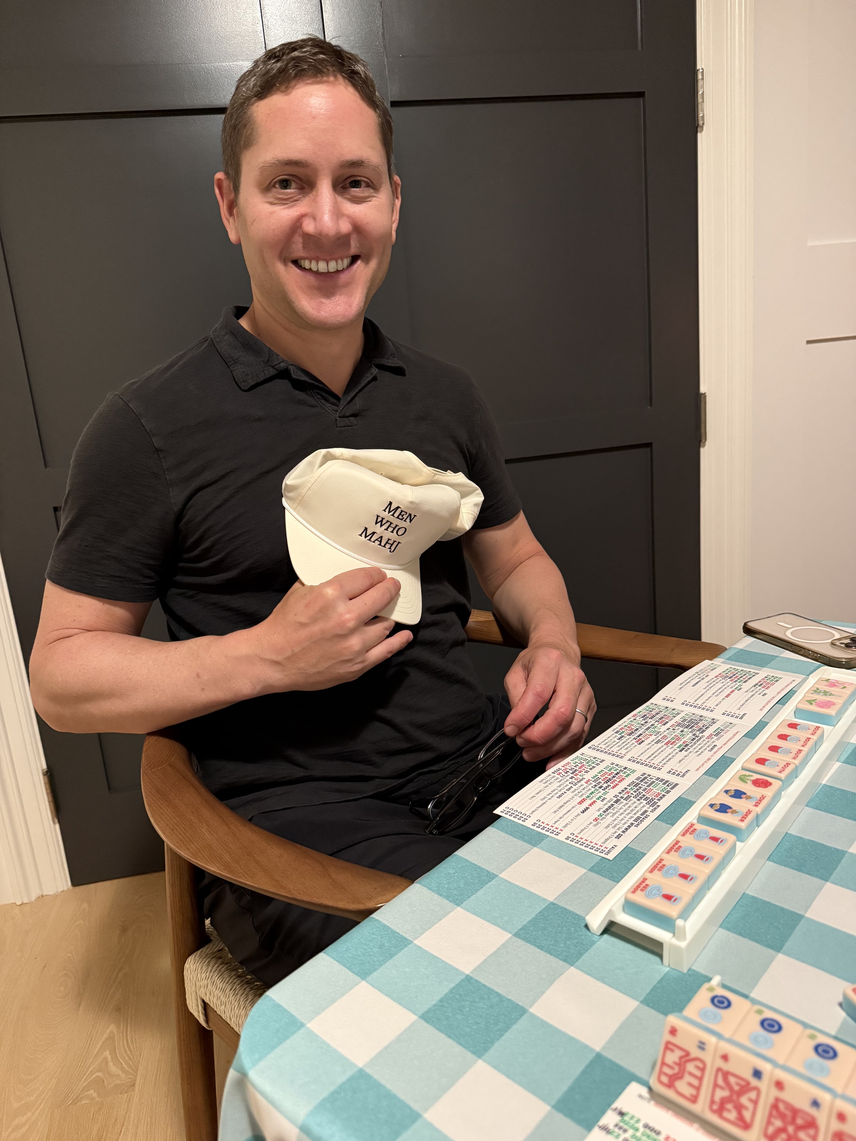 Man making peace signs at a mahjong table indoors